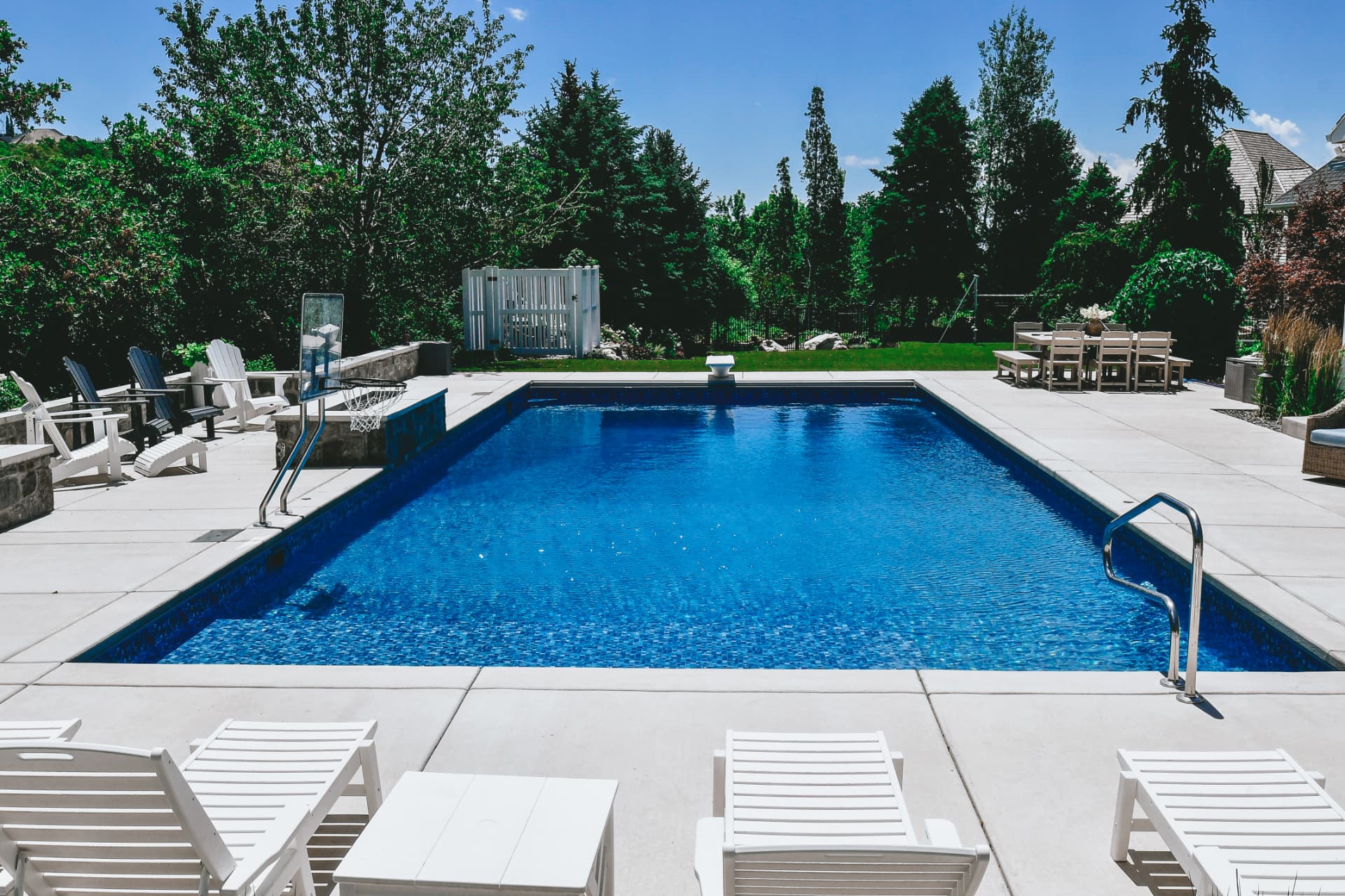 Custom vinyl swimming pool with fireside patio and lounge chairs built by Barr Pools in Davis County, Utah