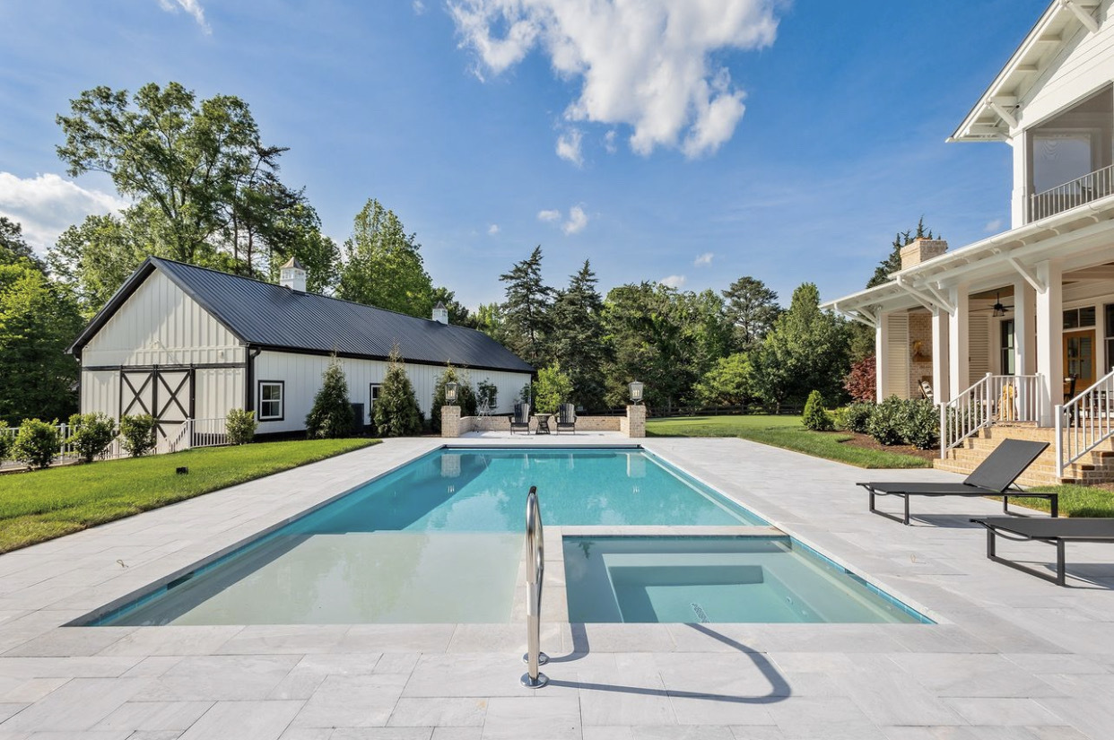 Kaysville Family Swimming Pool — Barr Pool Builders Backyard family swimming pool with surrounding patio in Kaysville, Utah custom built by Barr Pool Builders