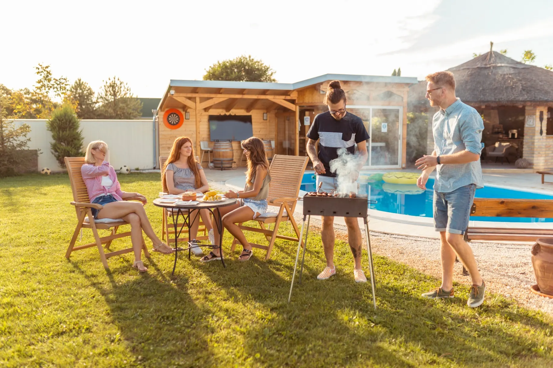 Poolside BBQ Entertaining - Barr Pool Builders Utah Friends grilling and entertaining poolside at a custom backyard vinyl swimming pool built by Barr Pool Builders in Utah