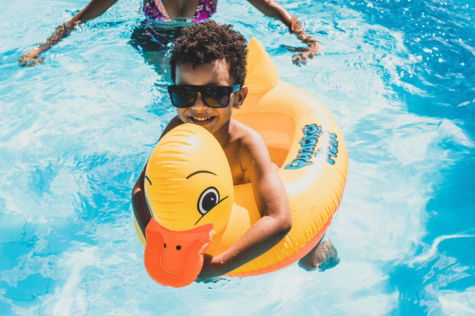 Happy child on a duck float enjoying a financed backyard swimming pool in Utah