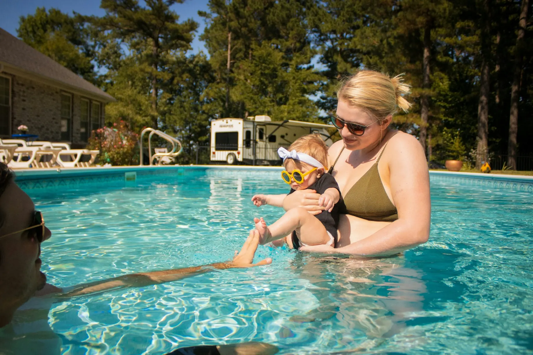Utah family with baby enjoying a safe, family-friendly vinyl swimming pool in the backyard