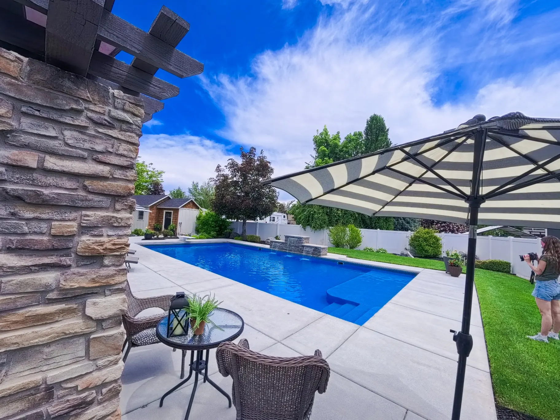 Farmington Utah Vinyl Pool with Stone Pergola - Barr Pool Builders Custom vinyl swimming pool with stone pergola, waterfall feature and expansive patio in Farmington, Utah by Barr Pool Builders