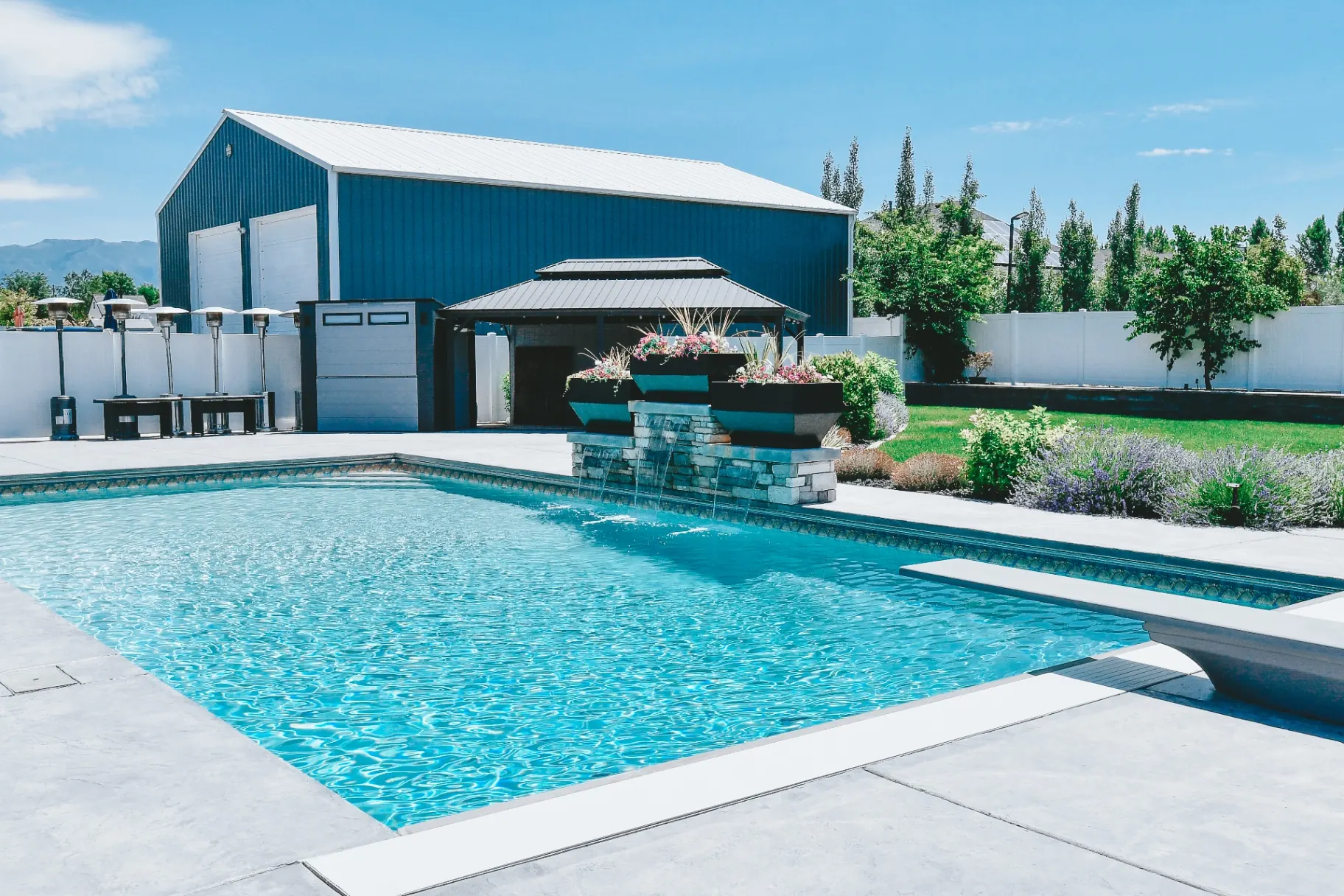 Backyard vinyl swimming pool with covered pavilion, outdoor heaters and shop in West Haven, Utah custom built by Barr Pool Builders